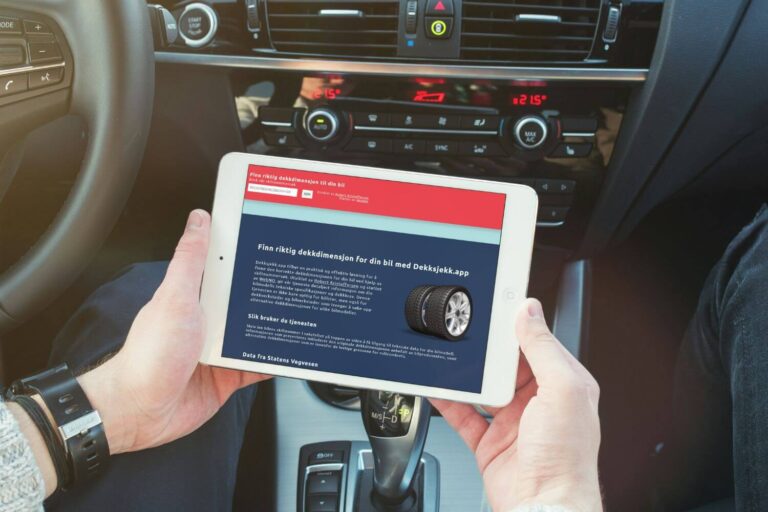 Dekksjekk.app avbildet på et nettbrett holdt i hånden i en bil.